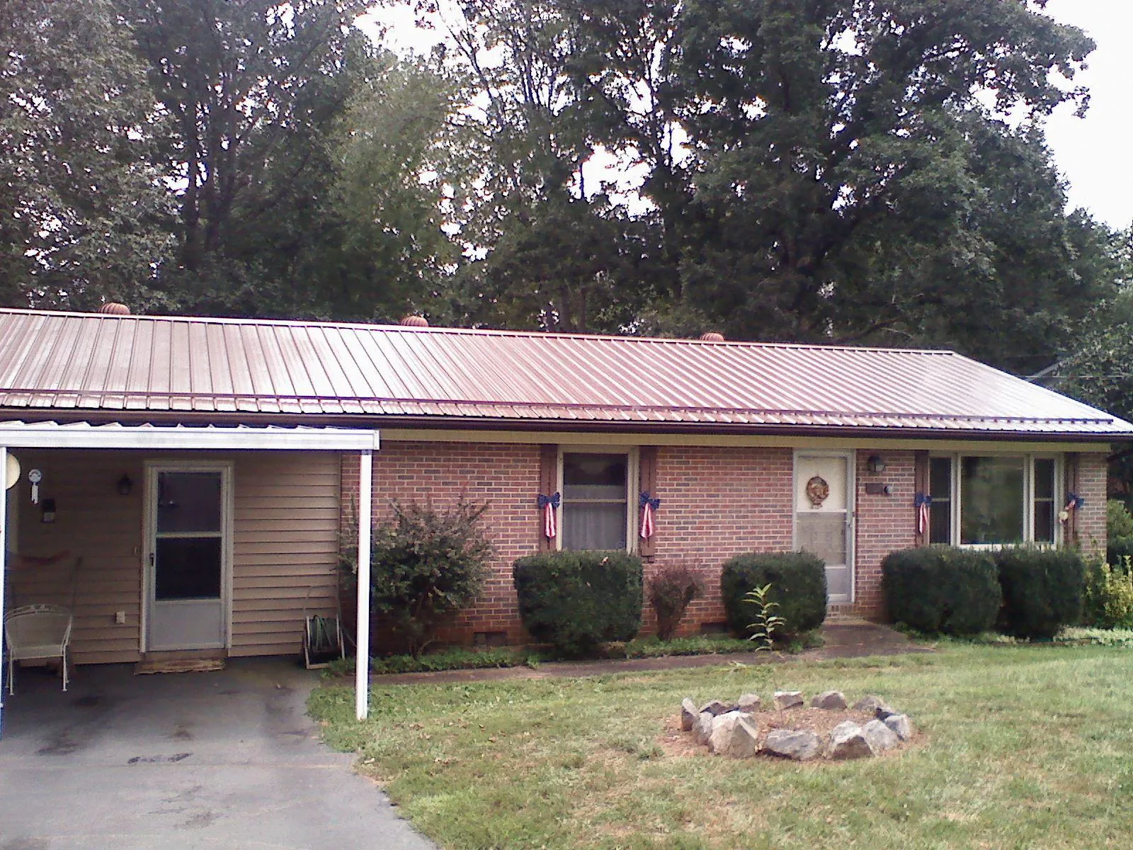 Bronze metal roof and carport on a brick ranch home — Roof Repair work by our crew in Templeton